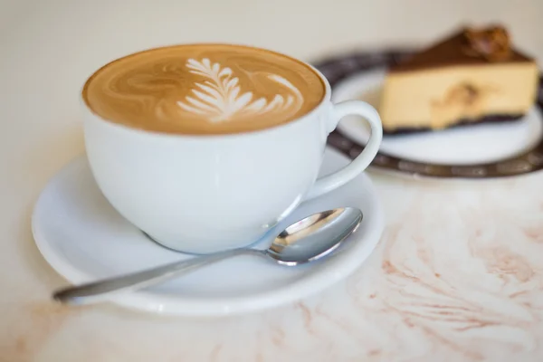 Café con capuchino o latte en una taza blanca con un pastel Fotos De Stock