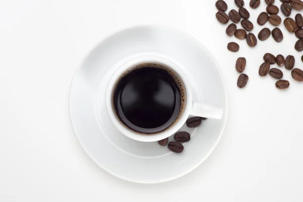 Чашка кофе и бобы на белом фоне. — стоковое фото