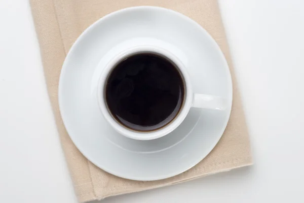 Cup of coffee on table napkin — Stock Photo, Image