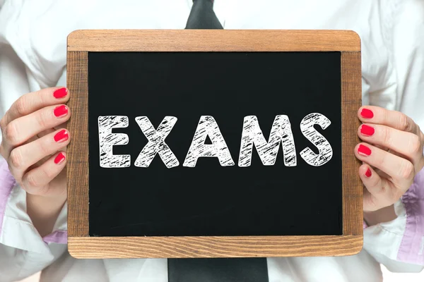 Ręce z egzaminów napis na tablicy — Zdjęcie stockowe