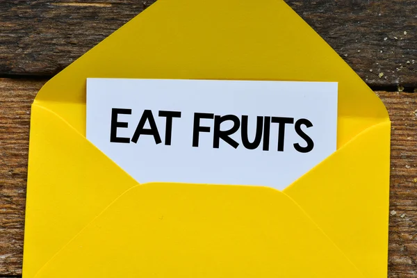 Message eat fruits on a white sheet — Stock Photo, Image