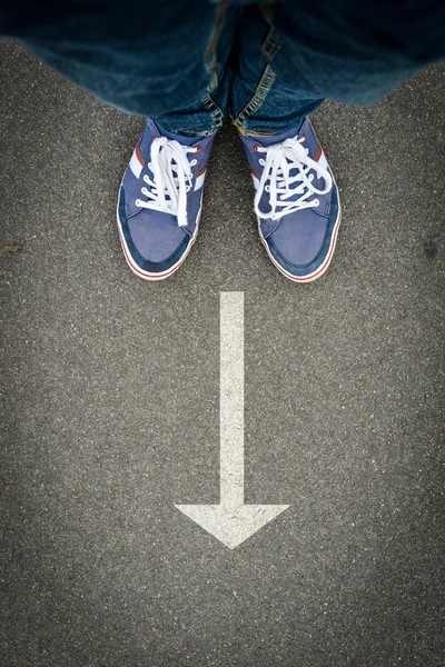 Legs on road with drawn direction arrow — Stock Photo, Image