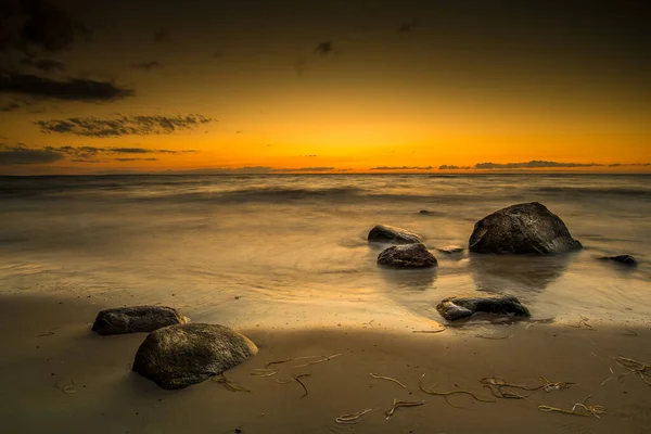 Zachód Słońca Nad Morzem Kamienie Piasek Morze Oświetlone Promieniami Zachodzącego — Zdjęcie stockowe