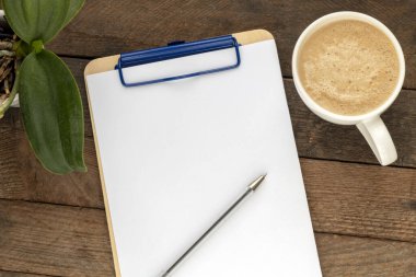 Boş not defteri ve kahve fincanı ofis tahtasının üzerinde.