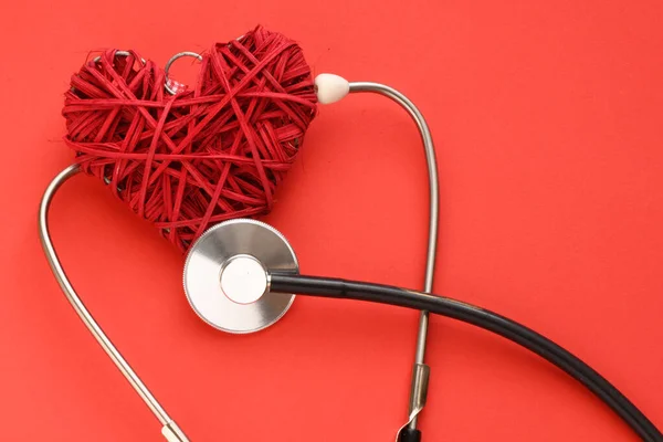 赤い背景の赤いハート 赤い背景の聴診器 ヘルスケアの概念 — ストック写真