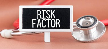 Risk faktörü metni steteskopun yanındaki küçük bir karatahtaya yazılmış. İlaç kavramı.