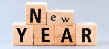 Gri arkaplandaki ahşap harflerle düzenlenmiş yeni yıl mesajı. Yeni yıl, yeni planlar, zorluklar, hedefler.