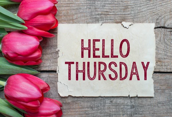 Tulips and paper with text Hello Thursday — Stock Photo, Image