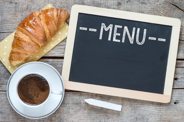 Vista aérea de una taza de café fresco y un croissant escamoso —  Fotos de Stock