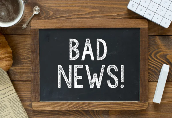 Bad News handwritten with white chalk — Stock Photo, Image