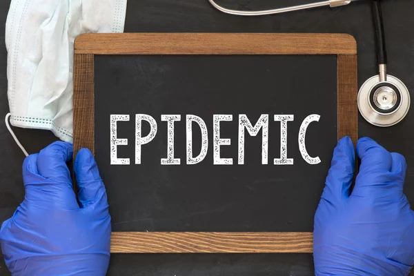 Medico in possesso di lavagna con la parola epidemia — Foto Stock