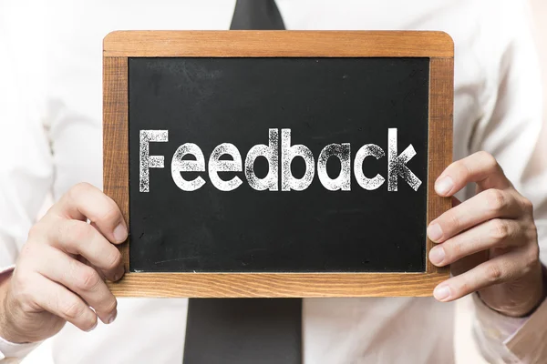 Affärsman med feedback word — Stockfoto