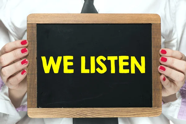 Blackboard with handwritten we listen — Stock Photo, Image