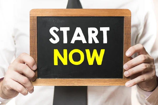 Businessman with start now on board — Stock Photo, Image