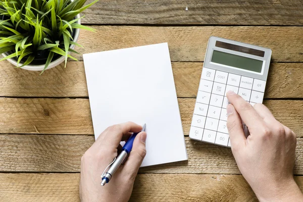 Hände mit Taschenrechner und Notizblock — Stockfoto