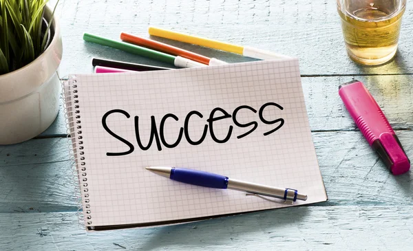 Notepad with success and markers