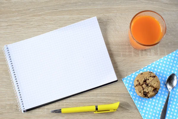 Carrot juice with cookie and empty notepad — Stock Photo, Image
