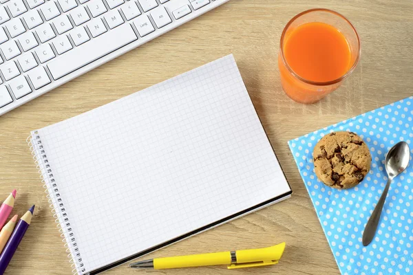 Karottensaft mit Plätzchen und leerem Notizblock — Stockfoto