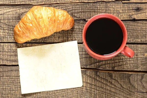Kopje zwarte koffie met croissant — Stockfoto