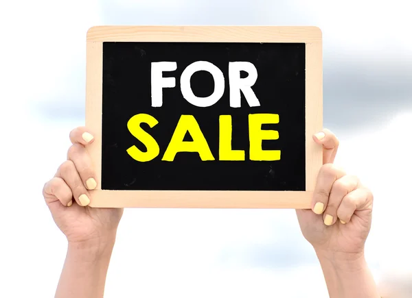 Ruce držící tabule s na prodej — Stock fotografie