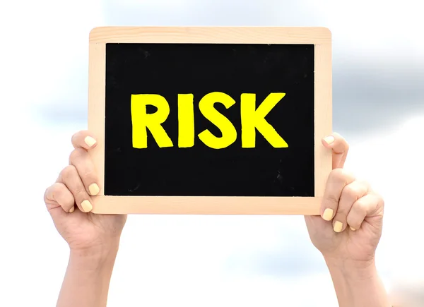 Hands holding blackboard with  risk — Stock Photo, Image