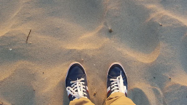 Piernas sobre fondo de arena — Foto de Stock