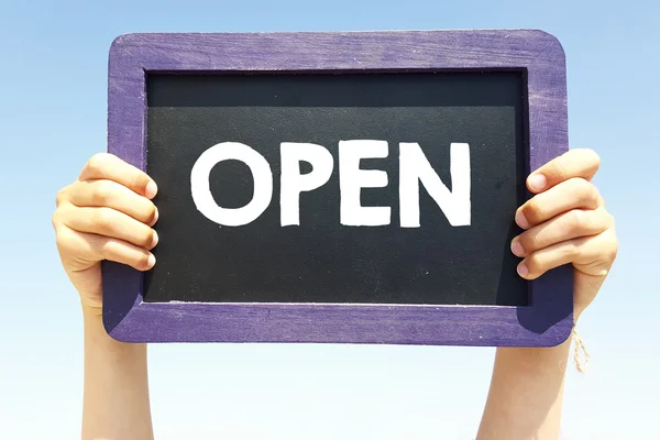 Hands holding blackboard with open — Stock Photo, Image