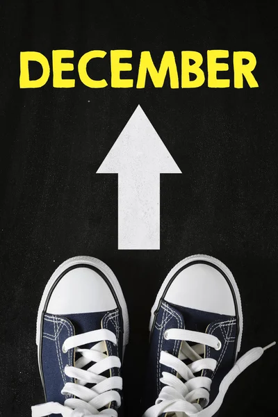 Zapatillas deportivas masculinas con flecha de dirección y diciembre —  Fotos de Stock