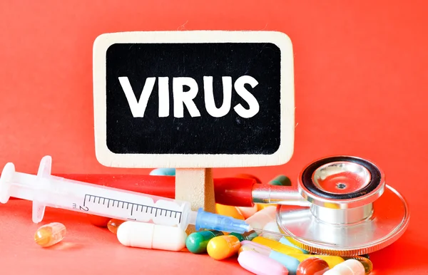 Дошка з вірусом і таблетками — стокове фото
