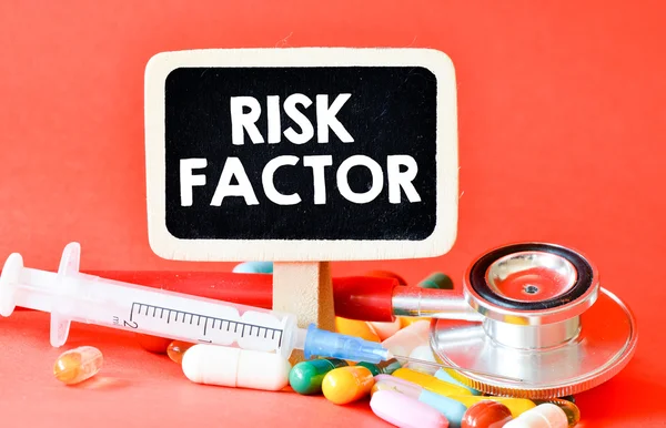 Pizarra con factor de riesgo y pastillas — Foto de Stock