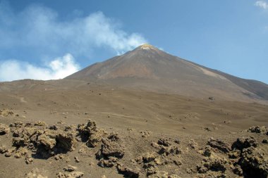 Sicilya, İtalya 'da güneşli bir günde açık mavi bir gökyüzünün altında Etna Dağı. Dramatik yamaçları ve doğal manzarası olan görkemli aktif volkan manzarası, Avrupa 'da popüler seyahat merkezi..