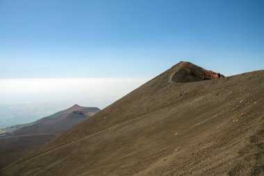 Sicilya, İtalya 'da güneşli bir günde açık mavi bir gökyüzünün altında Etna Dağı. Dramatik yamaçları ve doğal manzarası olan görkemli aktif volkan manzarası, Avrupa 'da popüler seyahat merkezi..