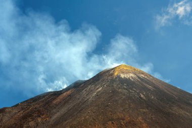 Sicilya, İtalya 'da güneşli bir günde açık mavi bir gökyüzünün altında Etna Dağı. Dramatik yamaçları ve doğal manzarası olan görkemli aktif volkan manzarası, Avrupa 'da popüler seyahat merkezi..