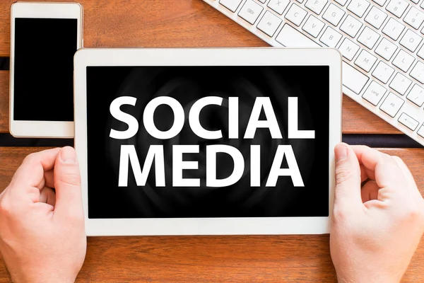 Handen met tablet pc met sociale media — Stockfoto