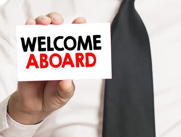 Hand with welcome abroad card — Stock Photo, Image