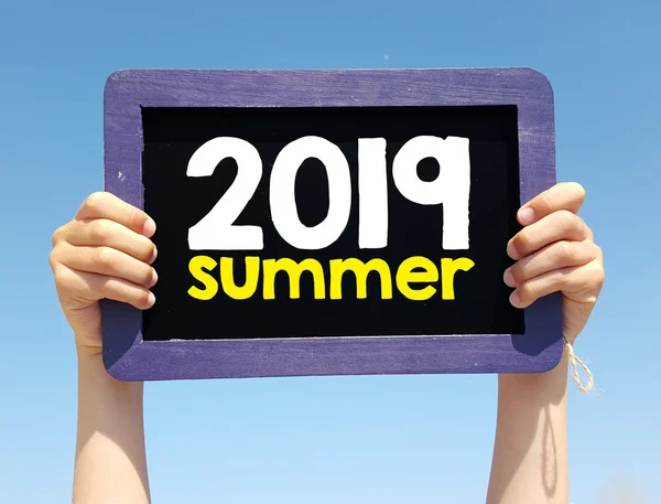 Handen met schoolbord met zomer 2019 — Stockfoto