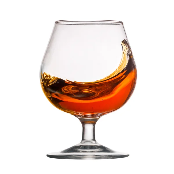 Splash van cognac in glas — Stockfoto