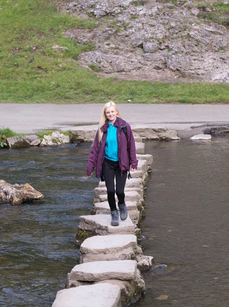 Young woman crossing stepping stones sovedale — Stock Photo, Image