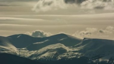 Karlı dağların üzerinde hareket eden bulutların hızlanması