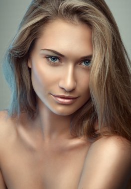 Gri arka plandaki güzel sarışın kız.