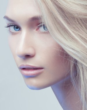 Gri arka plandaki güzel sarışın kız.