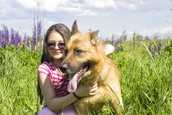 Chica abrazando a un perro al aire libre — Foto de Stock