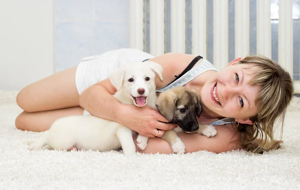 Mulher sorridente com filhotes de cachorro — Fotografia de Stock