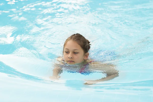 Menina nada na piscina — Fotografia de Stock