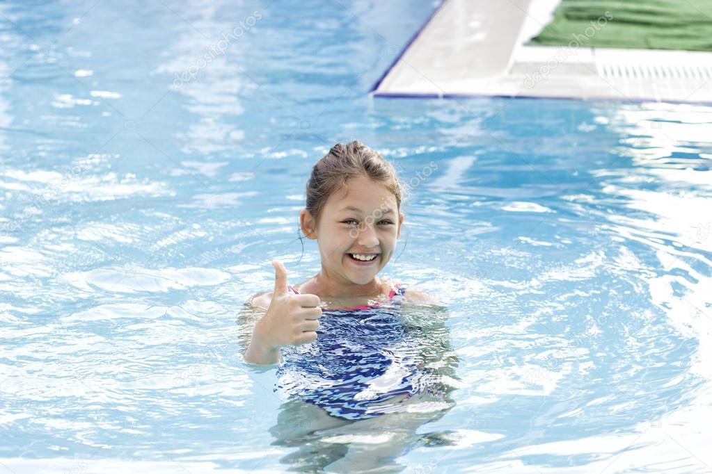 little girl swims in the pool