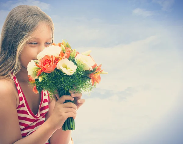 Chica oliendo un ramo de rosas — Foto de Stock