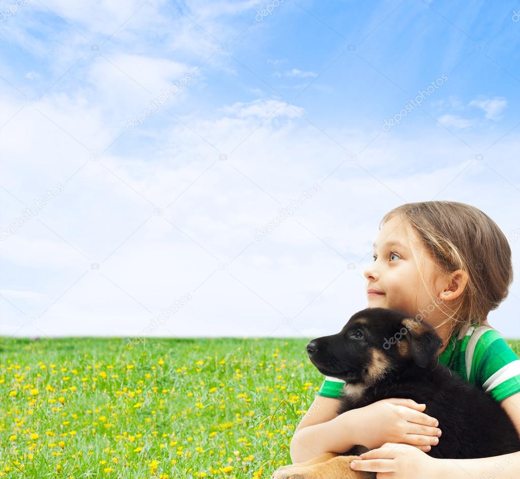 kid with his dog on a background of blue sky and green grass