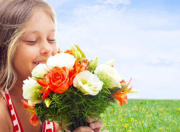 Bella bambina che annusa un bouquet sullo sfondo del cielo — Foto Stock