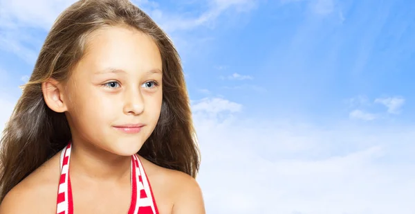 Веселая маленькая девочка на фоне голубого неба — стоковое фото
