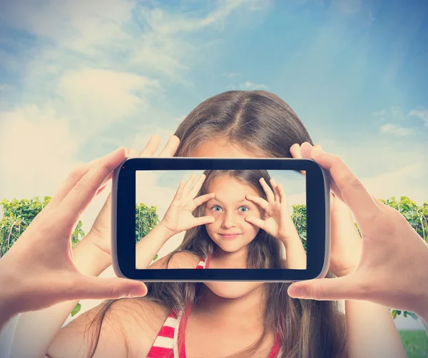 Grappig meisje gefotografeerd op een smartphone — Stockfoto